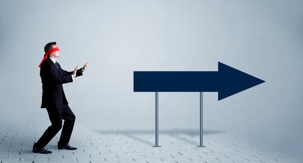 young sales person with blindfold with  arrow sign pointing forward